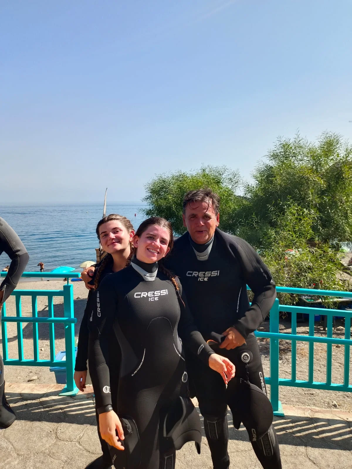 Tres buceadores junto al mar
